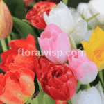 tulip bouquet arrangement in vibrant spring colors with roses and eucalyptus on a wooden table